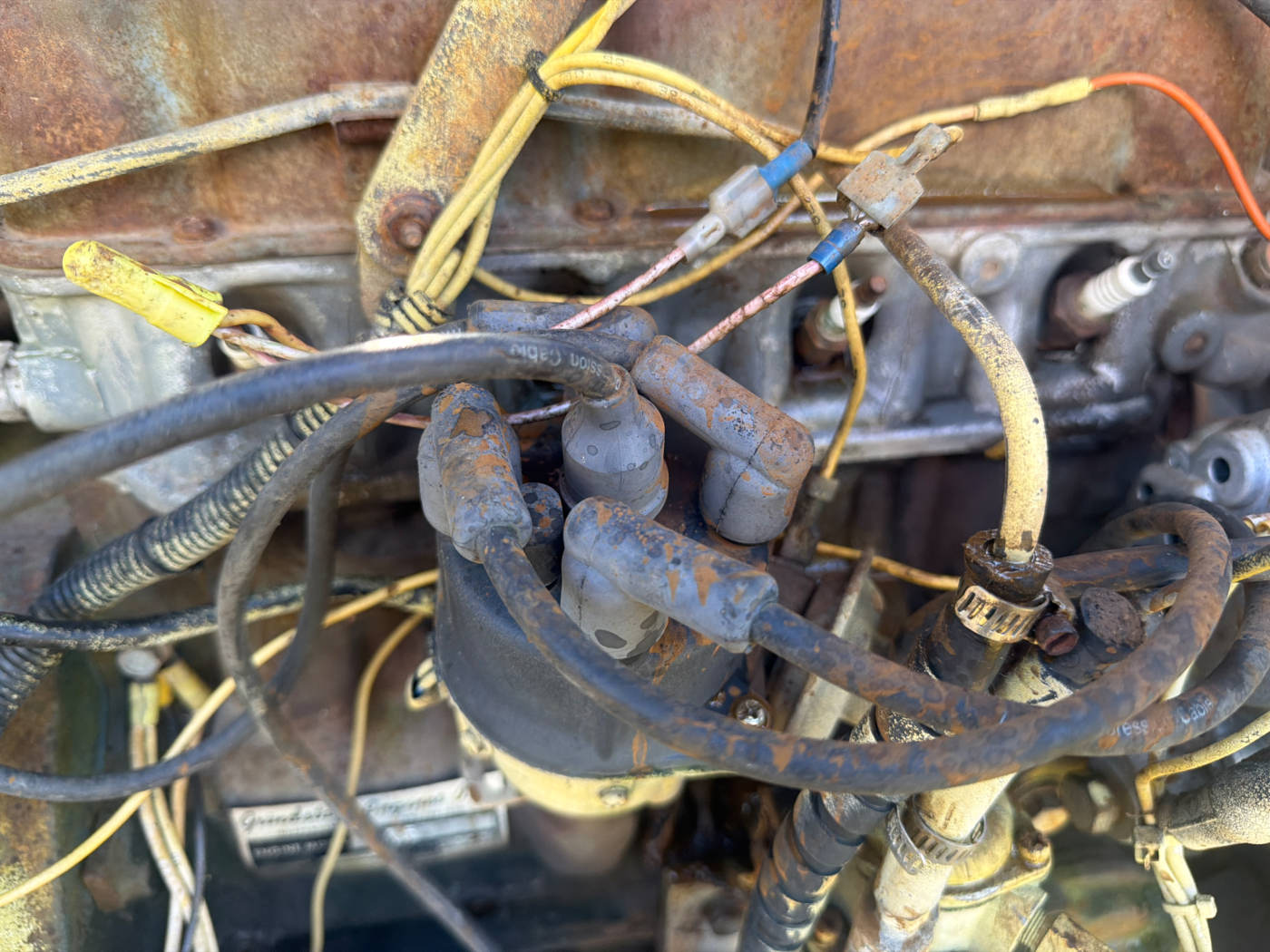 Distributor with cap on and all four plug wires still attached, Grindstaff engine tag visible below