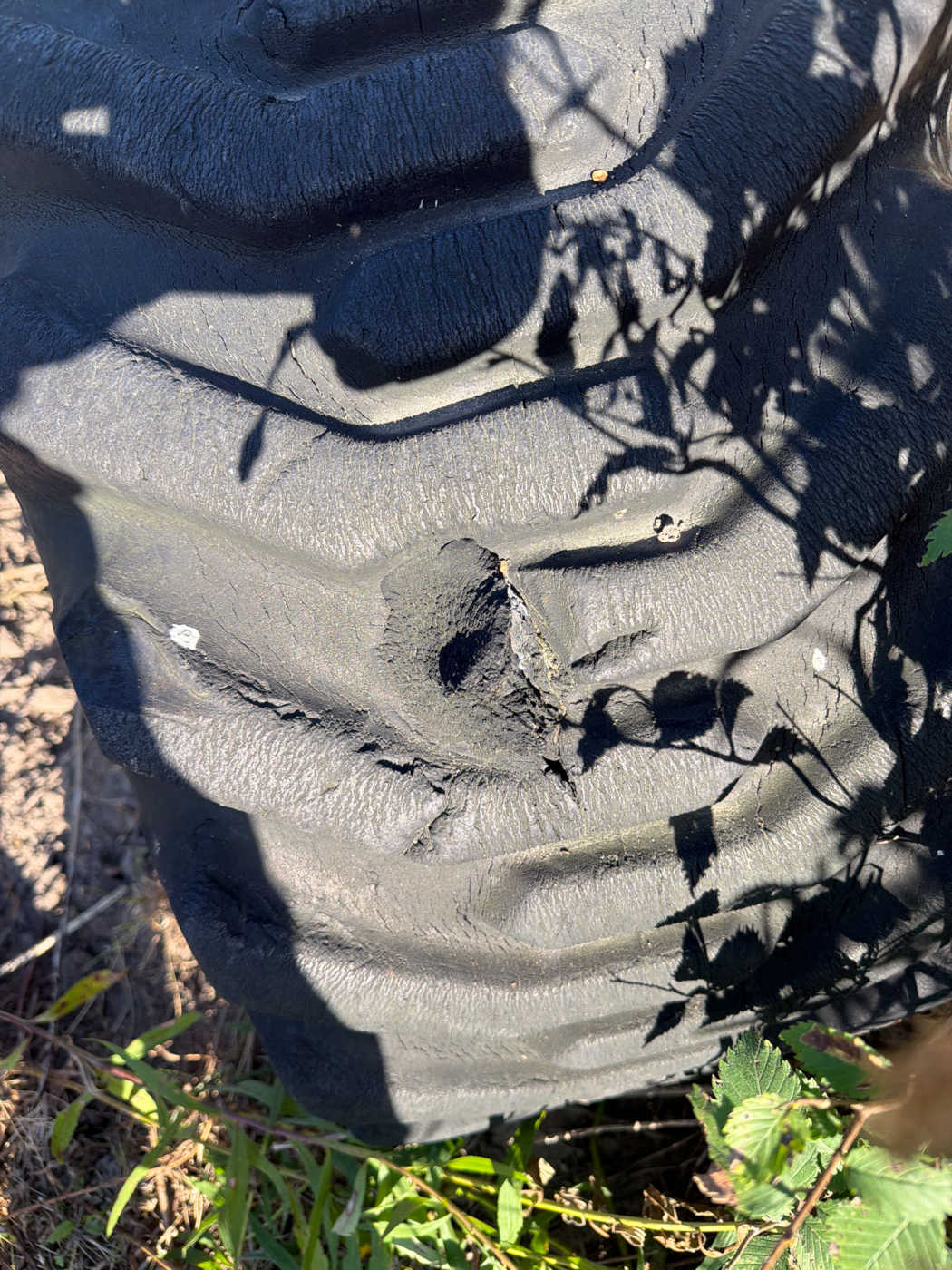 Front right tire with a large chunk gouged out of the tread and shoulder