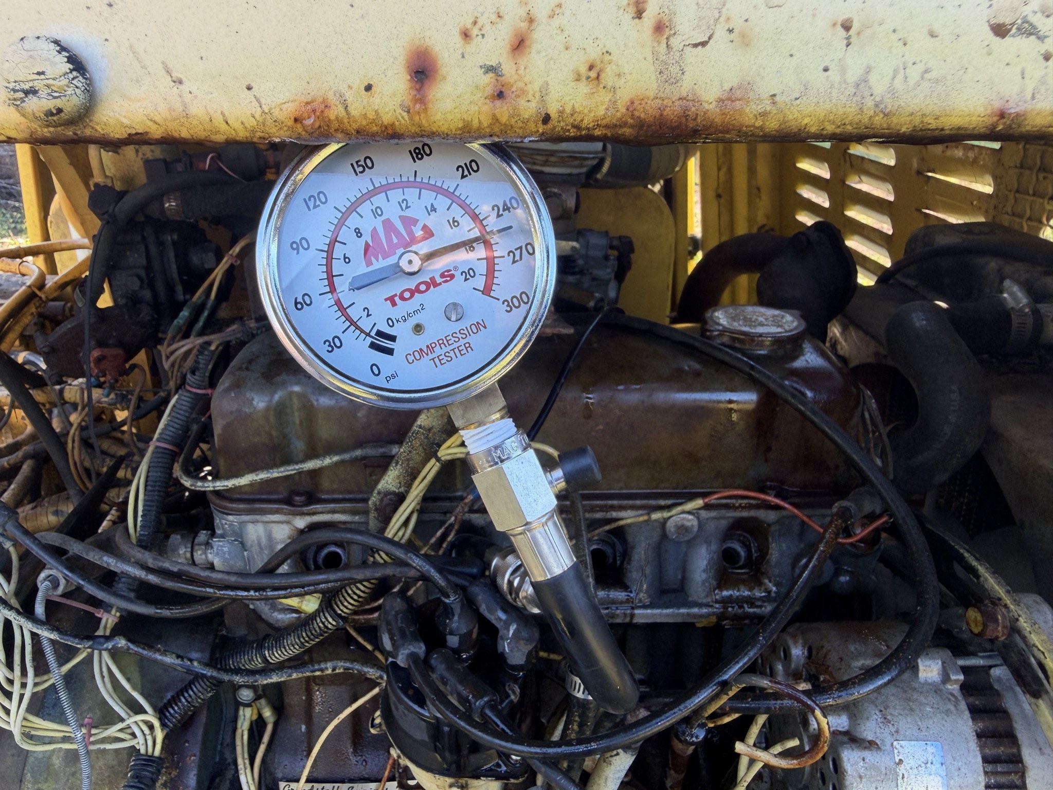 Compression gauge, pointer out at the 18 kg/cm2 mark between 240 and 270 psi