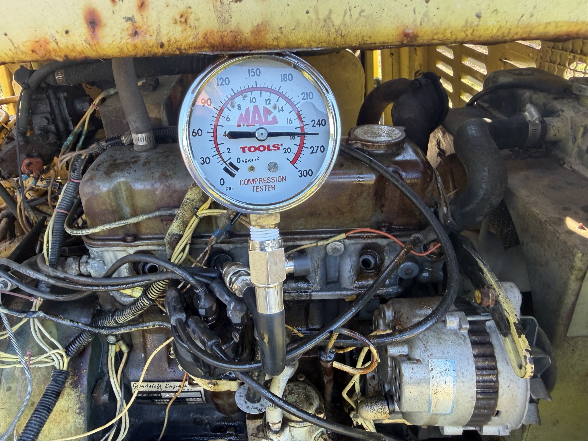 Compression gauge, pointer between 240 and 270 psi, counterweight lying on the 4 kg/cm2 mark