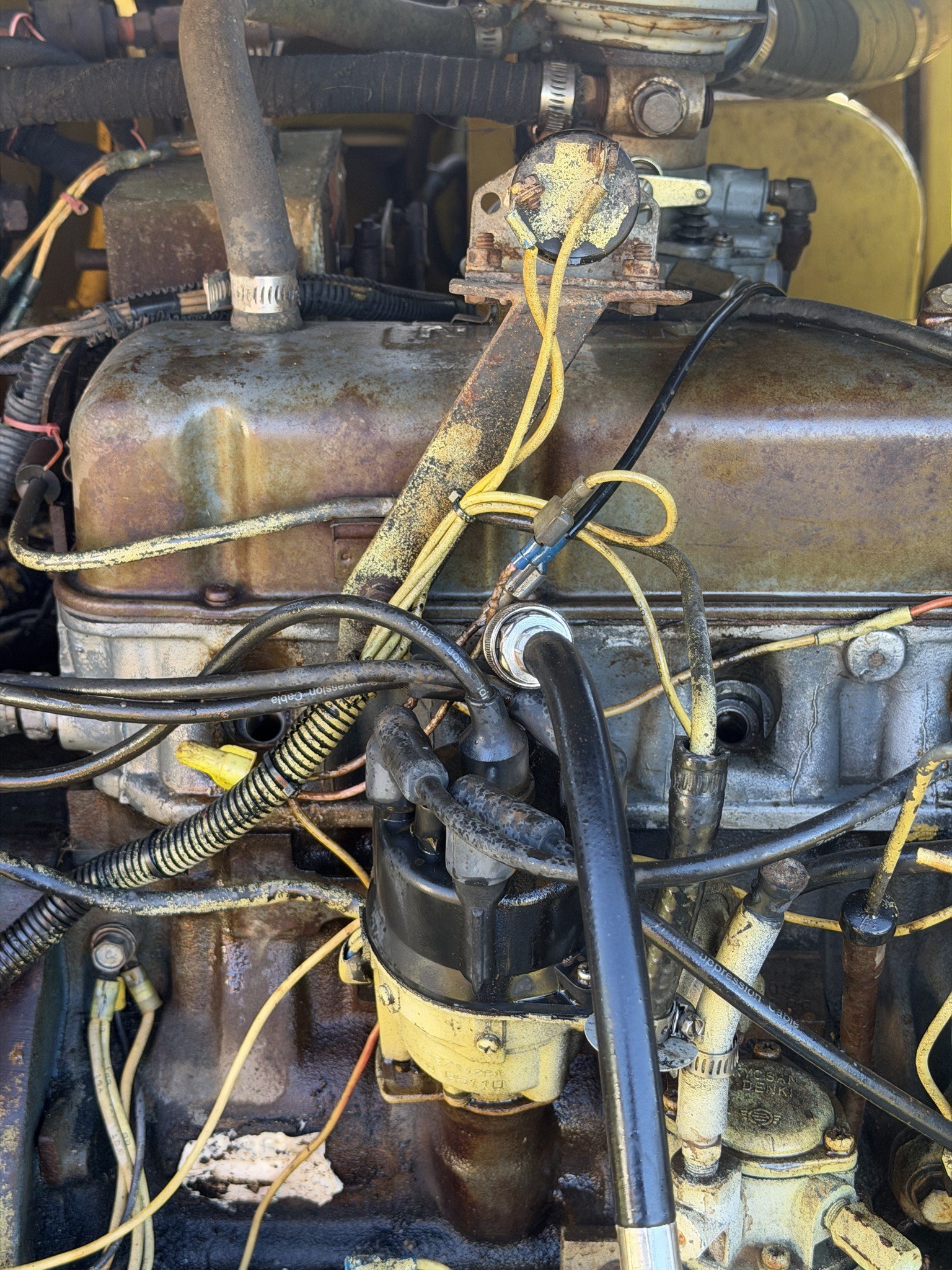 Cylinder head with the plugs out, compression tester adapter threaded into one hole
