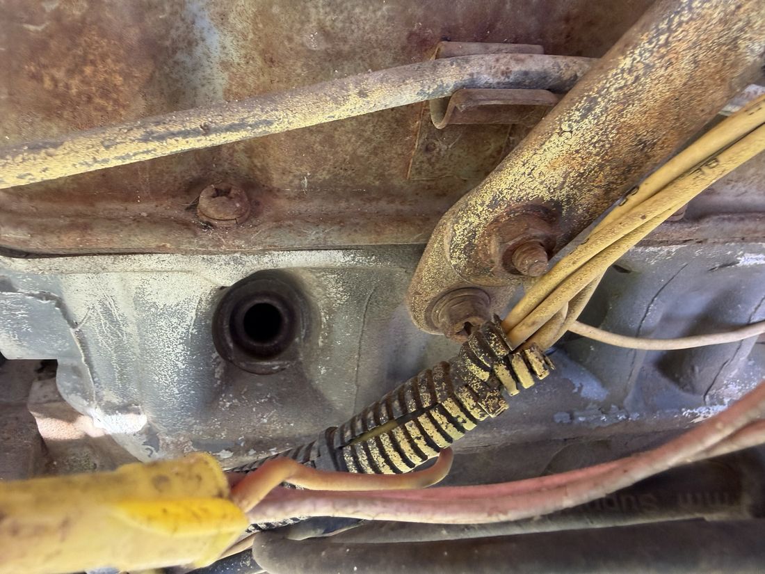 Underside of the engine bay, near the linkage